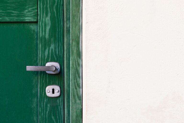 Close-up of a green door with a silver handle and keyhole